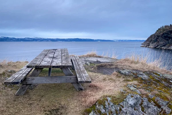 挪威特隆赫姆峡湾科尔斯维卡徒步旅行区冬季与多云的天空相对照的野餐桌 — 图库照片