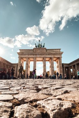 Berlin, Almanya - 13 Ekim 2021: Düşük açılı Brandenburg Kapısı bulutlu mavi gökyüzüne karşı