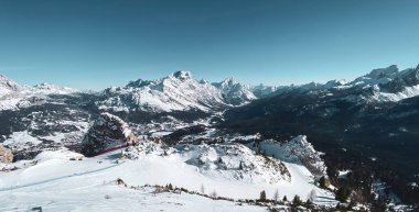 İtalya 'nın Dolomitler bölgesinde Cortina yakınlarındaki Ampezzo Vadisi' nin panoramik manzarası. Punta Sorapiss Dağı (solda) ve Antelao (sağda) kışın mavi gökyüzüne karşı.