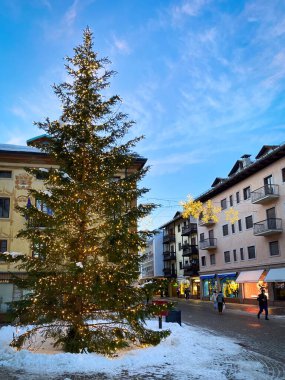 Cortina d 'Ampezzo, İtalya - 26 Ocak 2023 Kışın mavi gökyüzüne karşı aydınlatılmış Noel ağacı