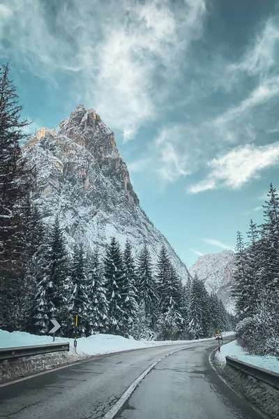 Dolomites, İtalya 'da SP51 yolunda kış mevsiminde Toblach' tan Cortina 'ya manzara Nasswand Croda Bagnata dağlı bulutlu mavi gökyüzüne karşı