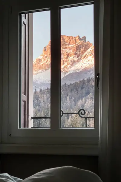 オレンジ色のスペラエステとドロマイトのペルモ山の景色 窓から見える冬の青空に日の出にイタリア — ストック写真