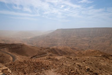 Mujib Kanyonu 'nun panoramik manzarası, Moujib Panorama' dan Ürdün, dolambaçlı yollarla mavi gökyüzüne karşı bulutlarla çevrili
