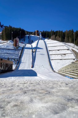 Courchevel, France - February 13, 2023: Ski jumping hill used for the Olympic Winter Games 1992 against blue sky clipart