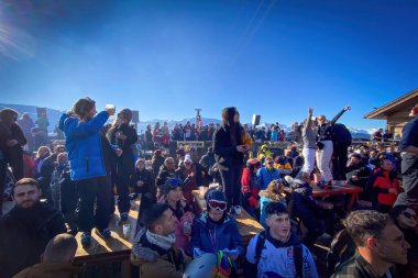 Meribel, Fransa - 12 Şubat 2023: La Folie Douce terasında kayak partisindeki insanlar, mavi gökyüzüne karşı