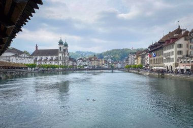 Lucerne, İsviçre 'nin kenti. Reuss nehri ve Cizvit Kilisesi. St. Francis Cavier, Chapel Köprüsü' nden bulutlu gökyüzüne karşı görüldü.