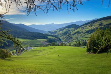 Güzel Val di Funes Villnoessertal manzaralı Güney Tyrol, İtalya 'da bulutlar batıya bakarken mavi gökyüzüne karşı