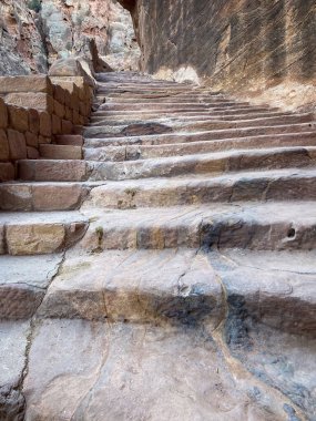 Ürdün 'ün tarihi ve arkeolojik kenti Petra' daki El-Khazneh Hazinesine giden El-Kaide Patikası (Indiana Jones Patikası) boyunca uzanan kayadaki merdivenler