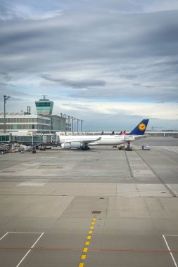 Münih, Almanya - 29 Nisan 2024: Önlük ve havaalanı Münih Havaalanı MUC, Almanya bulutlu gökyüzüne karşı