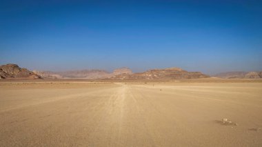 Ürdün 'deki Wadi Rum Çölü' nde dağların ve kaya oluşumlarının olduğu manzara mavi gökyüzüne karşı.