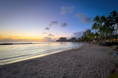 Honolulu 'daki Waikiki Sahili manzaralı Hawaii adası Oahu, ABD' de gün batımından sonra bulutlu renkli gökyüzüne karşı