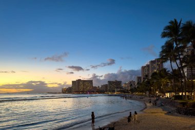 Honolulu 'daki Waikiki Sahili manzaralı Hawaii adası Oahu, ABD' de gün batımından sonra bulutlu renkli gökyüzüne karşı