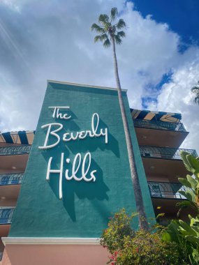 Beverly Hills, ABD - 31 Mart 2024: Beverly Hills Hotel, California 'nın önündeki bulutlu mavi gökyüzüne karşı ünlü 