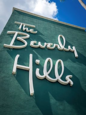 Beverly Hills, ABD - 31 Mart 2024: Beverly Hills Hotel, California 'nın önündeki bulutlu mavi gökyüzüne karşı ünlü 