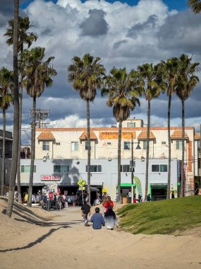 Venice Beach, ABD - 31 Mart 2024: Baharın güneşli bir gününde Ocean Front Walk 'da tahta kaldırımda olay yaşayan insanlar