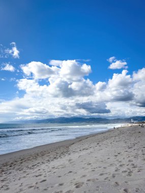 Santa Monica dağlarına ve bulutlu mavi gökyüzüne karşı Venedik Plajı, Los Angeles, Kaliforniya manzarası