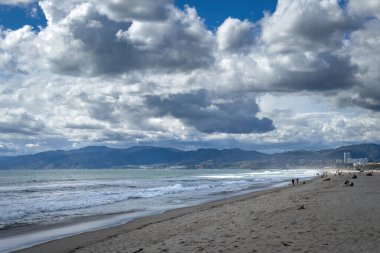 Santa Monica dağlarına ve bulutlu mavi gökyüzüne karşı Venedik Plajı, Los Angeles, Kaliforniya manzarası