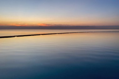 Ölü Deniz 'de gün batımı Ürdün' ü ön planda yüzme havuzuyla İsrail 'e doğru götürüyor.