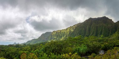 ABD 'nin Oahu kentindeki Hawaii Adası' ndaki Ho 'omaluhia Botanik Bahçesi' nden görülen yeşil dağlı manzara bulutlu gökyüzüne karşı