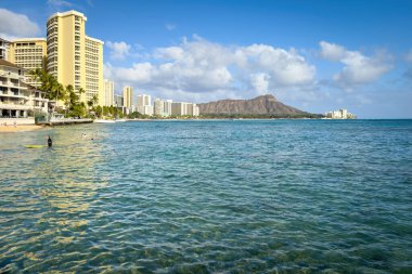 Honolulu, Hawaii, ABD - 2 Nisan 2024: Oahu adasında şehir manzarası bulutlu mavi gökyüzüne karşı Waikiki Sahili