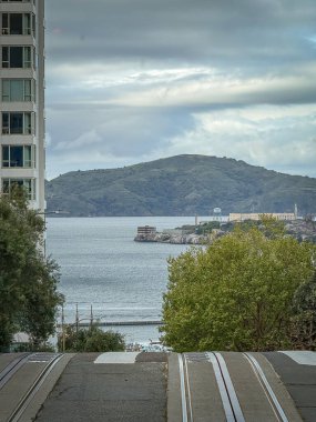Hyde Caddesi, San Francisco, California, ABD 'den görülen Alcatraz Adası manzaralı bulutlu gökyüzüne karşı