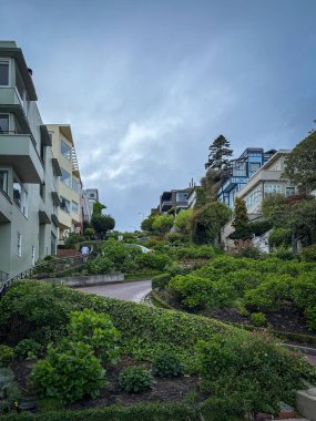 San Francisco, Kaliforniya 'daki Lombard caddesinde bulutlu gökyüzüne karşı rüzgarlı yol manzarası