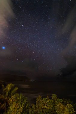 Hawaii 'nin kuzey kıyısındaki Kauai adasının manzarası. Gökyüzü yıldızlarla dolu.