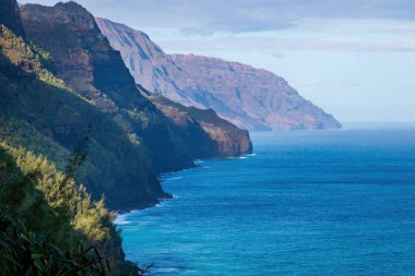 Kalalau Patikası, Kauai, Hawaii, ABD 'den görülen muhteşem Napali Sahili manzarası sabah bulutlu mavi gökyüzüne karşı