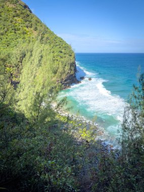 Beautiful and dangerous Hanakapiai Beach at low tide seen from Kalalau Hiking Trail on the Hawaiian island of Kauai, USA against blue sky clipart