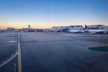 San Francisco, California, USA - July 25, 2022: Apron and airport building at SFO International Airport against blue sky clipart