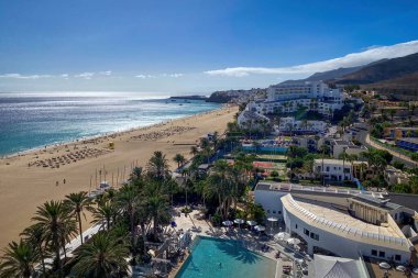 Playa del Matorral plajı manzarası ve İspanya 'nın Fuerteventura adasındaki Morro Jable kasabası mavi gökyüzüne karşı.