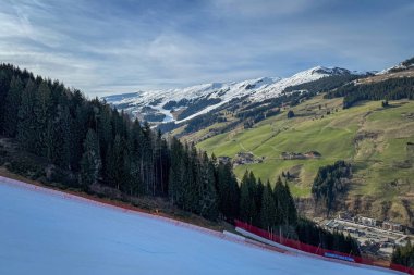 Saalbach-Hinterglemm, Avusturya - 22 Mart 2024: Dünya Şampiyonası 'na ev sahipliği yapmadan bir yıl önce 12er Kogel' de yeşil çayırlar ve alp kayak dünya kupası eğimi ile kayak bölgesinin manzarası