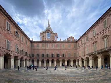 Turin, Italy  April 24, 2022: Wide angle shot of of Piazzetta Reale and Chapel of the Holy Shroud against blue sky with clouds. clipart