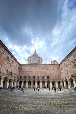 Turin, Italy  April 24, 2022: Wide angle shot of of Piazzetta Reale and Chapel of the Holy Shroud against blue sky with clouds. clipart