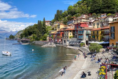 İtalya 'nın Como Gölü' nün doğu kıyısındaki güzel renkli Varenna kasabasının manzarası bulutlu mavi gökyüzüne karşı