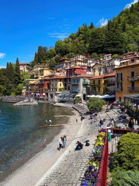 İtalya 'nın Como Gölü' nün doğu kıyısındaki güzel renkli Varenna kasabasının manzarası bulutlu mavi gökyüzüne karşı