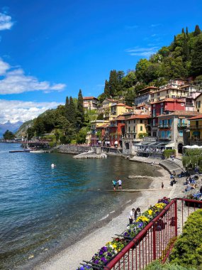 İtalya 'nın Como Gölü' nün doğu kıyısındaki güzel renkli Varenna kasabasının manzarası bulutlu mavi gökyüzüne karşı