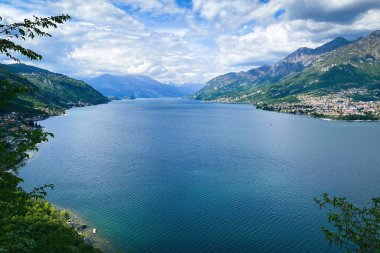 Mandello del Lario (sağda) ve Onno (solda) köyü ile kuzeye bakan Como Gölü ve güneydoğu dalının manzarası mavi gökyüzüne karşıdır.