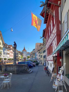 Cityscape of Sempach, Switzerland with fountain and Ox Gate Ochsentor against blue sky clipart