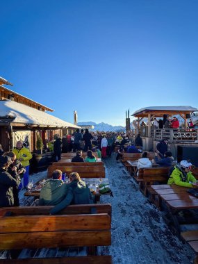 Alta Badia, İtalya - 17 Aralık 2023: Club Moritzino 'nun terasında apres kayak partisindeki insanlar - Piz la Ila mavi gökyüzüne karşı