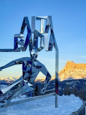 Alta Badia, İtalya - 17 Aralık 2023: Dev Alta Badia Heykel Heykeli Piz la Ila 'da Heiligkreuzkofel Dağı' na karşı kayak heykeli ve gün batımında mavi gökyüzü