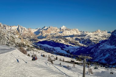 Gardena Geçidi 'nden Kufar Alta Badia' ya ve Fanes Grubu 'nun dağlarına manzara. Cuntrines, Lagazuoi, Tofana di Rozes, Güney Tyrol, İtalya Mavi gökyüzüne karşı