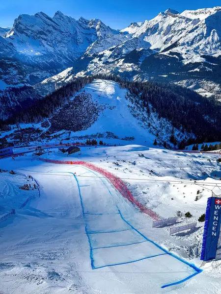 Wengen, İsviçre - 13 Ocak 2024: Efsanevi Hundschopf atlayışı manzarası Lauberhorn kayak alpin pistinde mavi gökyüzüne karşı.