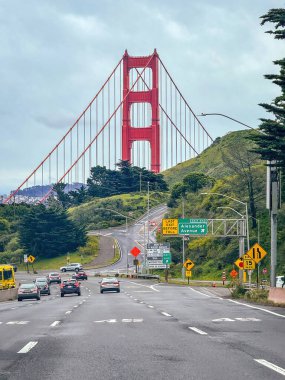 San Francisco, California, ABD - 13 Nisan 2024: Bulutlu gökyüzüne karşı caddeden Golden Gate Köprüsü manzarası