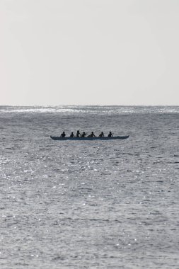 Avara Demiri kanosu, ABD 'nin Hawaii eyaletindeki Oahu adasının kıyısında tek bir teknede ışığa karşı kürek çekiyor.