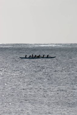 Avara Demiri kanosu, ABD 'nin Hawaii eyaletindeki Oahu adasının kıyısında tek bir teknede ışığa karşı kürek çekiyor.