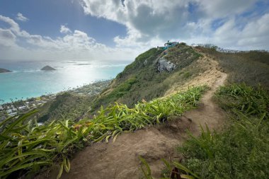 Kailua, Oahu, Hawaii, ABD - 5 Nisan 2024: Ka 'iwa Ridge Lanikai Pillbox yolu ve Lanikai Sahili manzaralı mavi gökyüzü bulutlu ikiz adalar