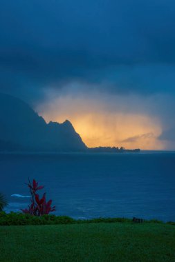 Hawaii 'nin Kauai adasının kuzey kıyılarının manzarası. Yağmurlu bir günde gün batımında ünlü Napali kıyılarıyla.
