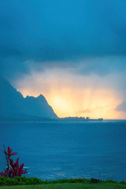 Hawaii 'nin Kauai adasının kuzey kıyılarının manzarası. Yağmurlu bir günde gün batımında ünlü Napali kıyılarıyla.