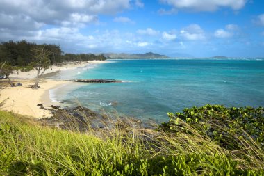 Kailua Sahili ve Kailua Körfezi 'nin Oahu, Hawaii adasındaki manzarası bulutlu mavi gökyüzüne karşı.